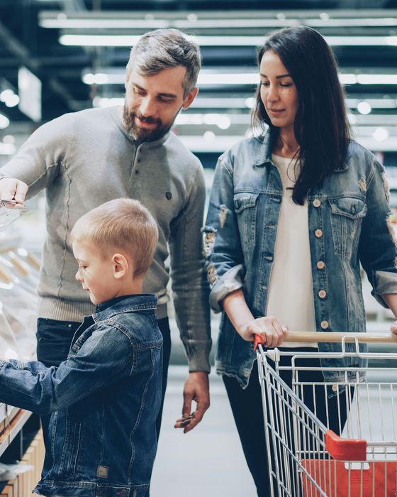 A family choosing bread together while grocery shopping in a supermarket