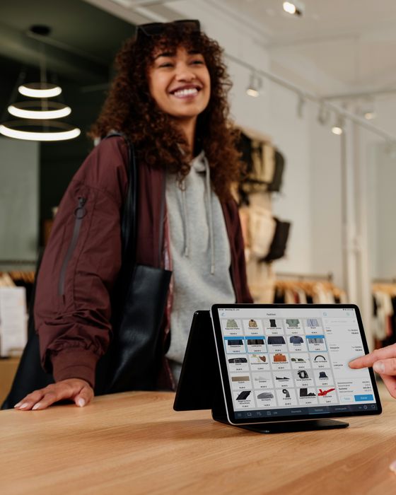 A smiling shopper at the counter of a clothing store
