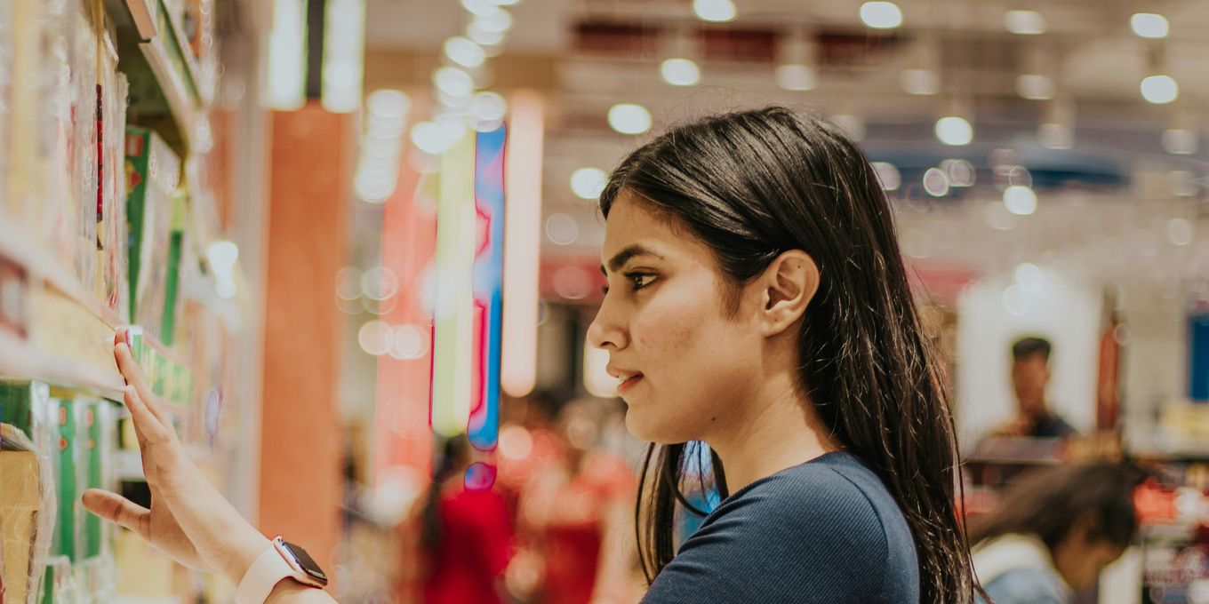 A woman browsing beauty products on a store shelf