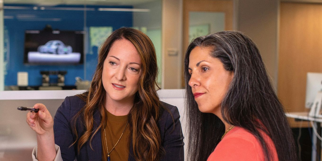 Two marketing leaders reviewing work together on a computer screen