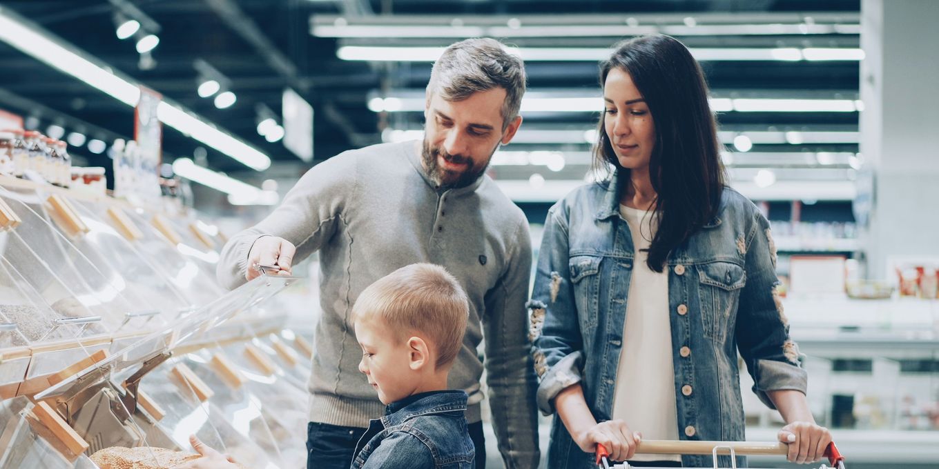 A family choosing bread together while grocery shopping in a supermarket