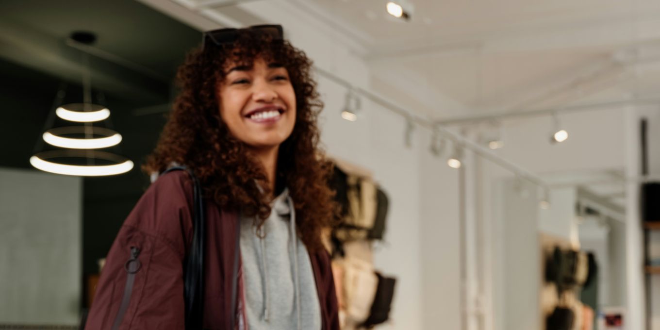 A smiling shopper at the counter of a clothing store