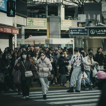 Crowd of people crossing a busy city street