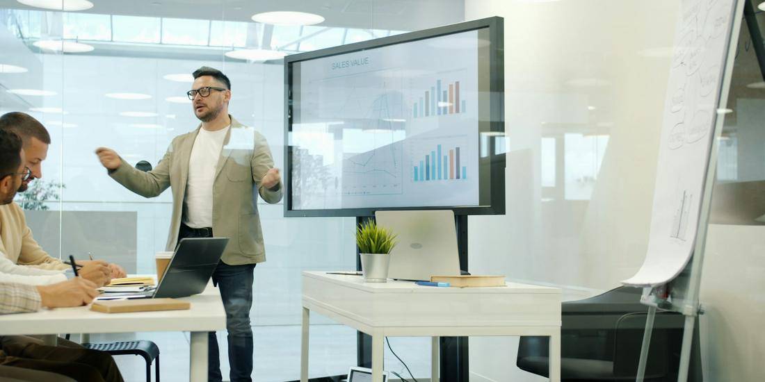 Presenter showing charts to a team in a meeting room