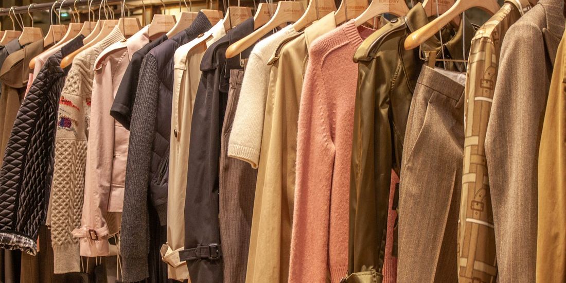 Knitwear and jackets in warm tones hanging on a clothing rack